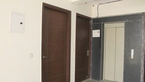 A hallway with three doors, one of which is a lift. - Hotel South Delhi Inn (New Delhi)