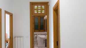A hallway leading to a kitchen with a radiator, a washing machine, and a sink. - Mary's House, Agerola (Pianillo)