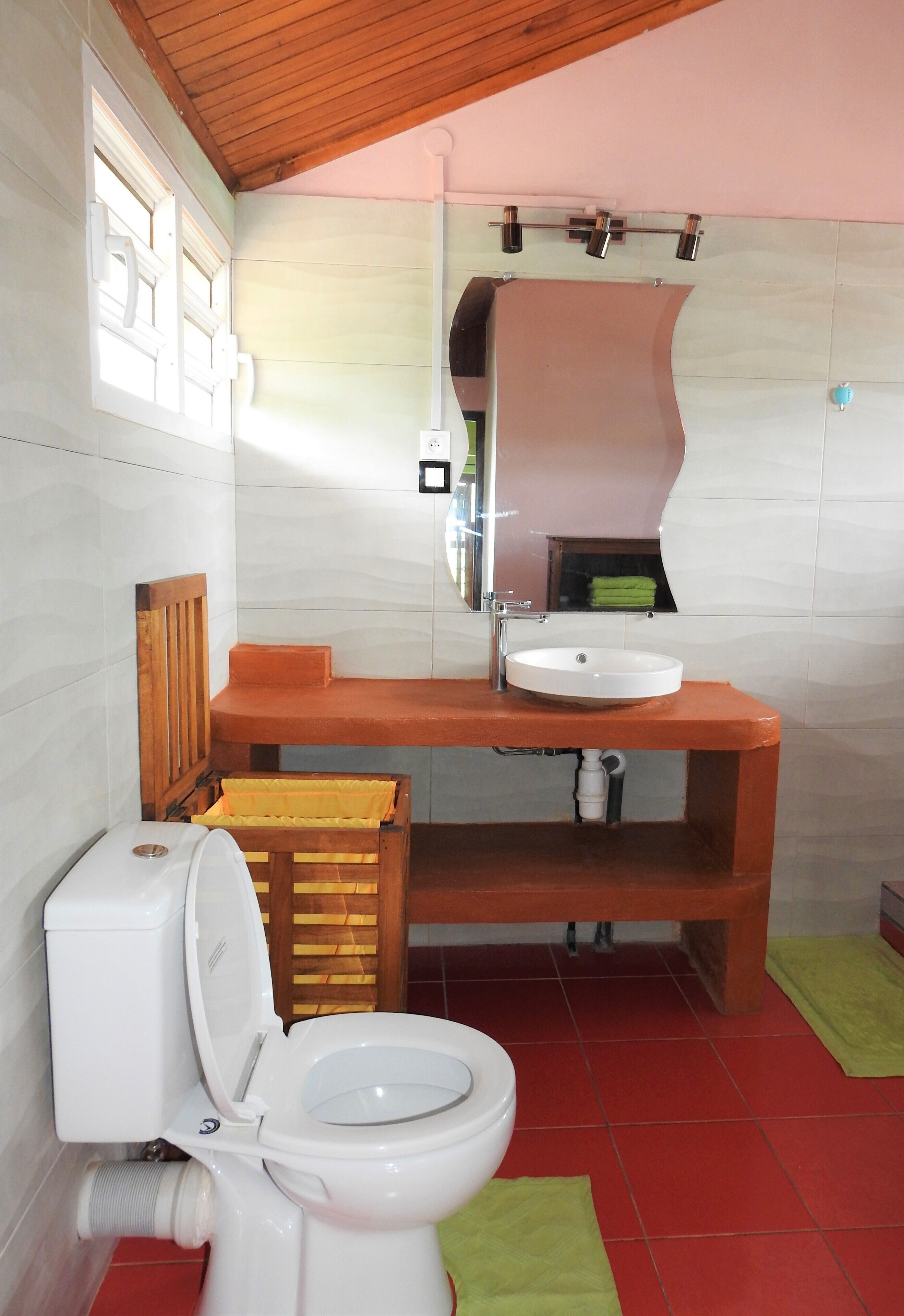 Un baño con inodoro, lavabo y espejo.