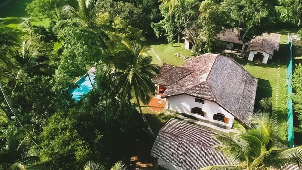 An aerial view of a house surrounded by lush greenery, including palm trees and a swimming pool. - The Mugatiya (Ahangama)