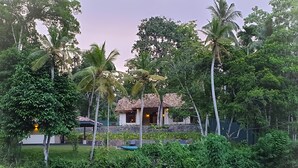 A house with a tiled roof, surrounded by lush greenery and palm trees. - The Mugatiya (Ahangama)