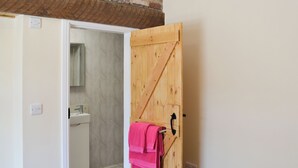A bathroom with a wooden door, a sink, and a mirror. - 3 bedroom accommodation in Flamborough (Flamborough)