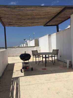 Enjoy al fresco dining on the patio, where a barbecue grill and table with chairs await.