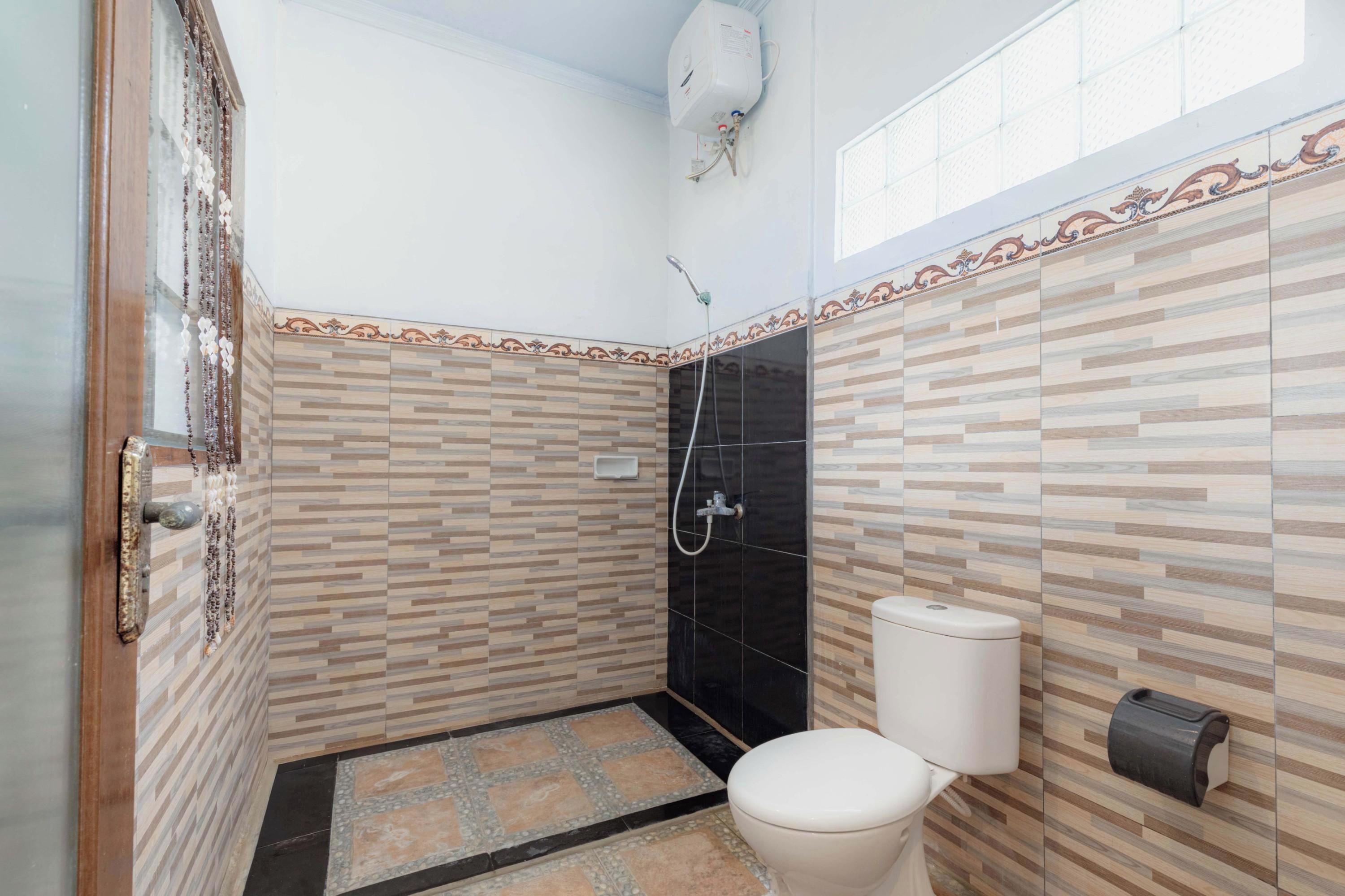 A bathroom with a shower, toilet, and a water heater mounted on the wall.