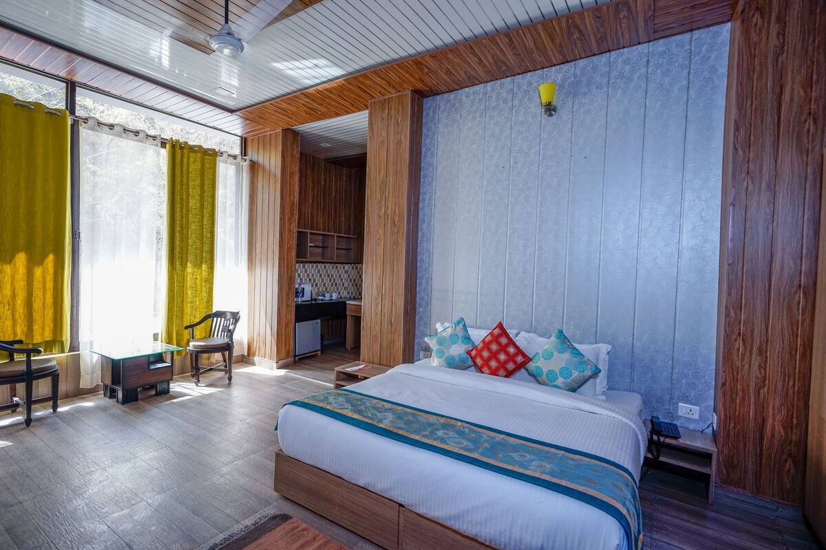 A bedroom with a large bed, wooden headboard, and a desk with a chair.