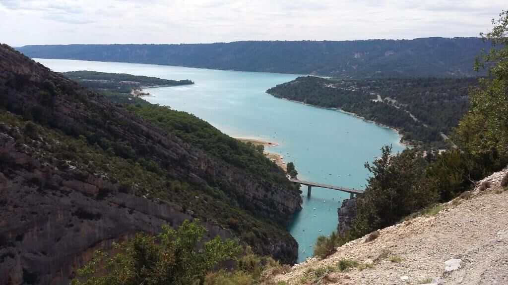 Un paysage côtier avec un pont, des falaises et une étendue d’eau.