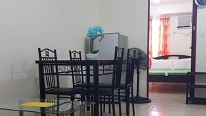Un espace de vie compact comprenant un coin repas, une petite kitchenette et un lit.