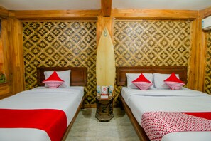 A hotel room with two beds, each with a red and white patterned bedspread, wooden headboards, and red pillows. - OYO 867 Bettah Coba Homestay (Cikakak)