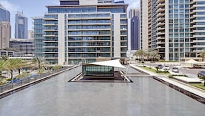 A modern hotel with a central courtyard, surrounded by high-rise buildings. - Al Majara 5 by Deluxe Holiday Homes (Dubai)