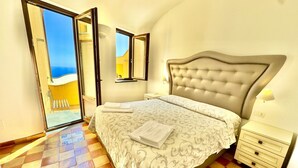 Una camera da letto con un letto, un comodino, una cassettiera e vista all'esterno.