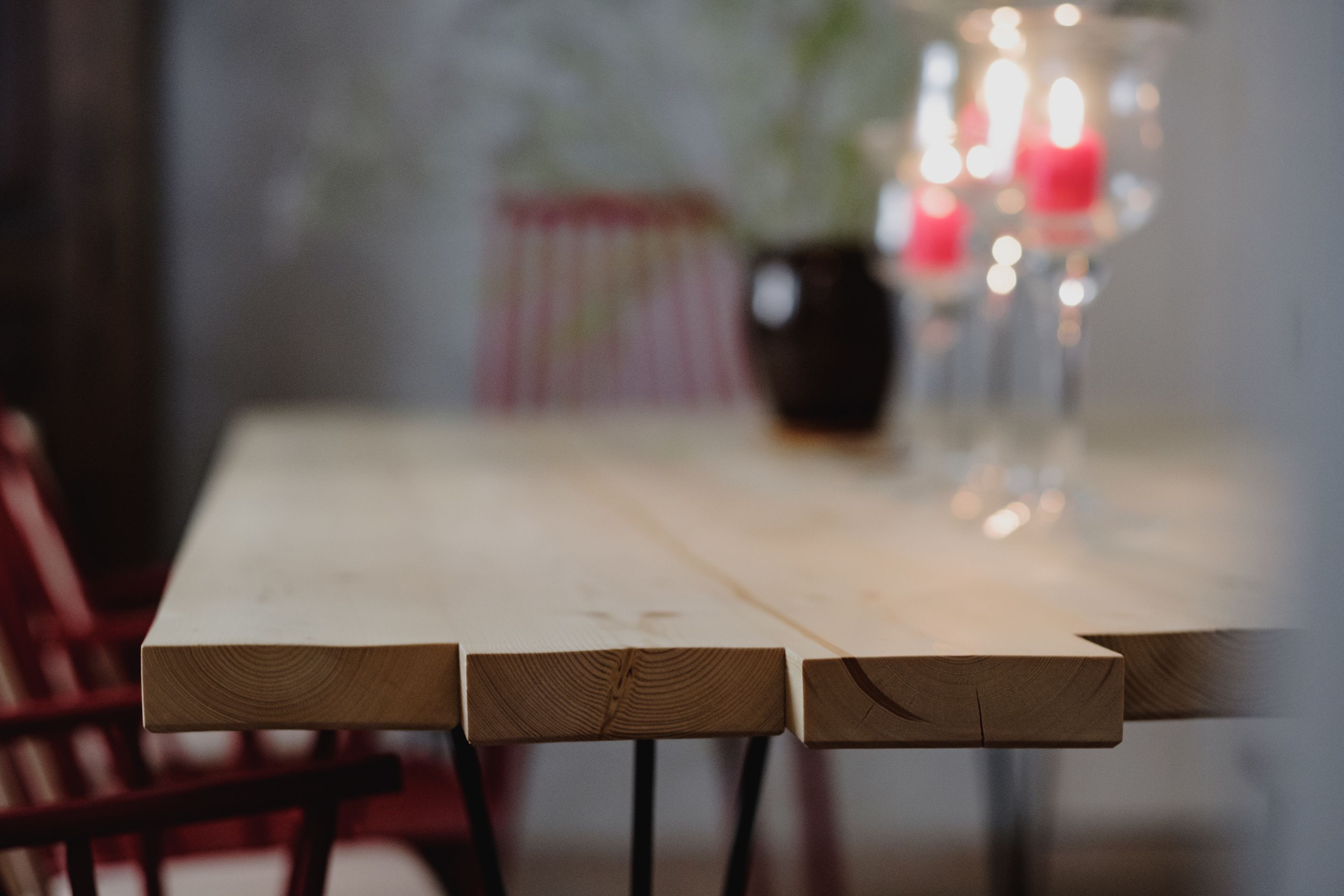 Une table en bois avec des chaises, une plante en pot et un chandelier avec des bougies.