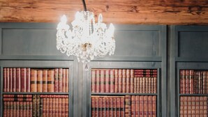 Un sillón rojo frente a una estantería llena de libros.