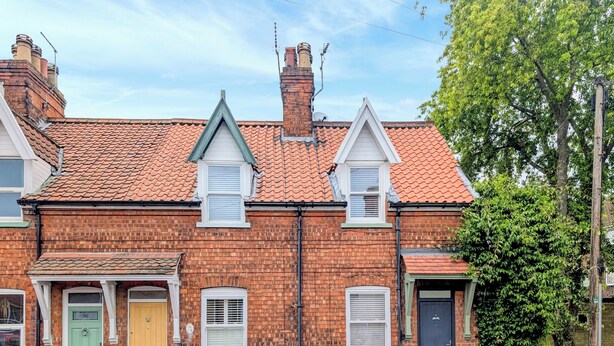 A two-story brick house with a red-tiled roof, two chimneys, and a green door. - 2 bedroom accommodation in Beverley (Beverley)