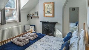 A bedroom with a bed, a fireplace, a window, and a framed picture on the wall. - 2 bedroom accommodation in Beverley (Beverley)