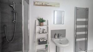 A modern bathroom with a shower, toilet, sink, and towel rack. - 2 bedroom accommodation in Beverley (Beverley)