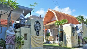 A traditional building with a tiled roof, a stone statue, and a sign that reads "PARA". - The Box Paradise Bungalow (Penida Island)