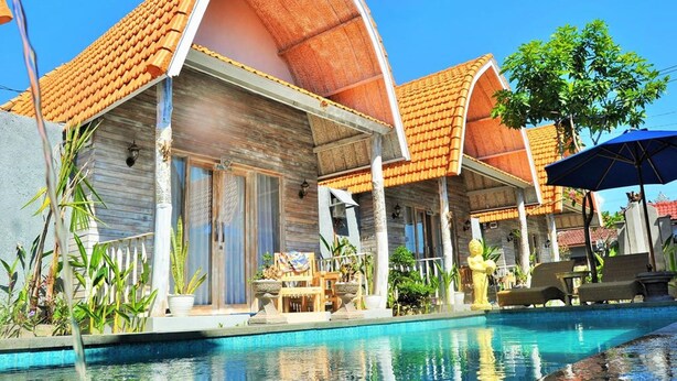 A resort with a swimming pool, wooden villas with tiled roofs, and outdoor seating areas. - The Box Paradise Bungalow (Penida Island)