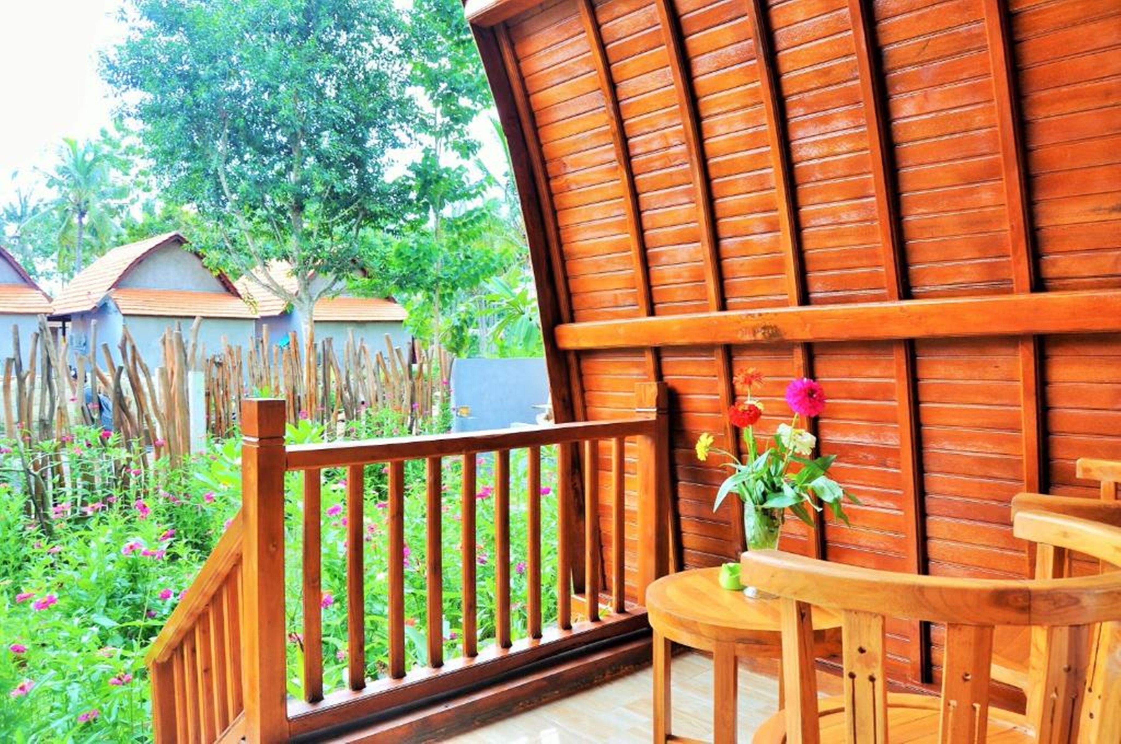 Un balcon en bois avec une balustrade en bois, une petite table et une chaise.