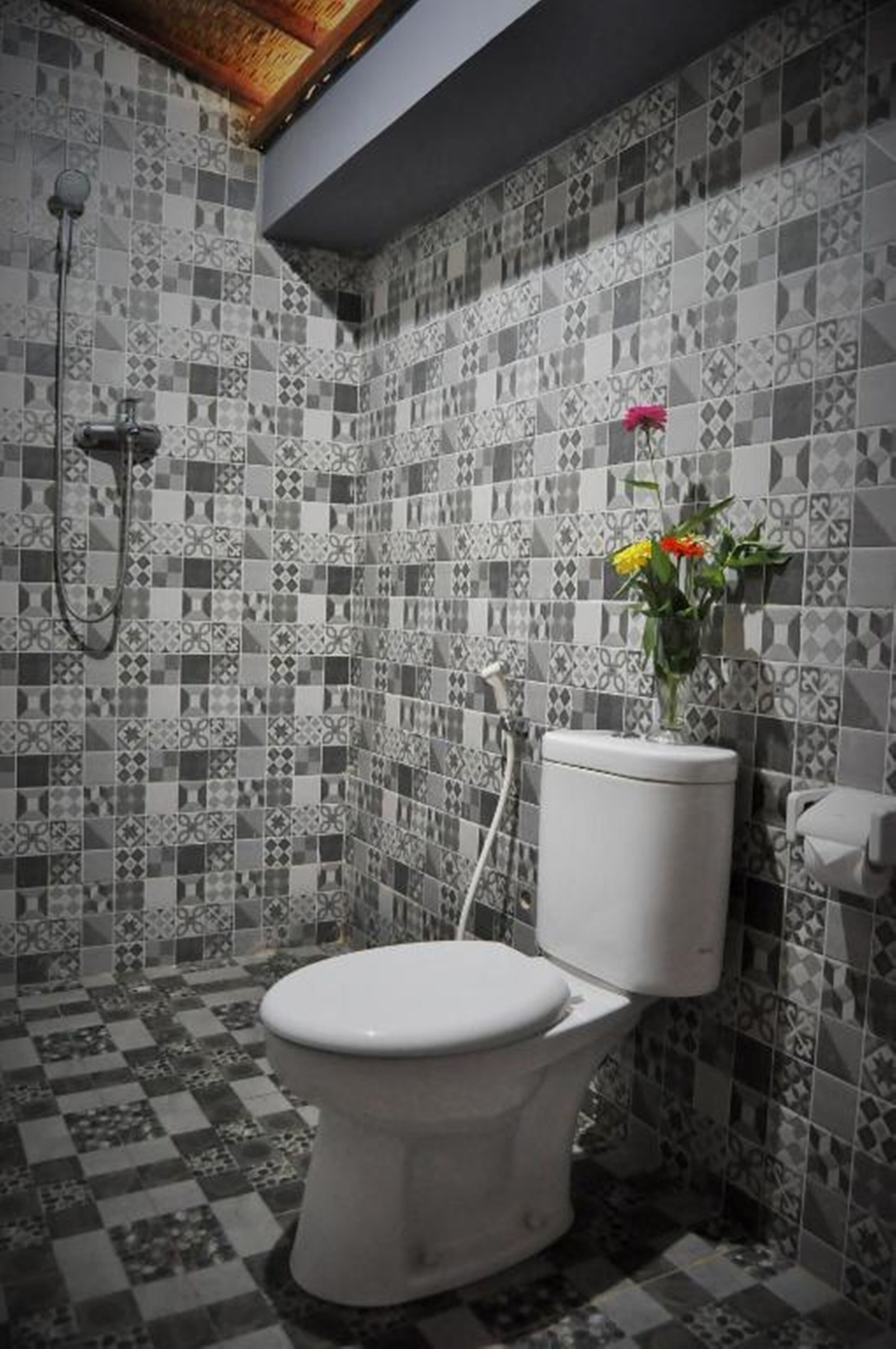 Un bagno con il water, doccia e pareti piastrellate.