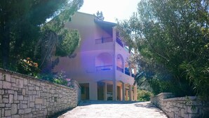 Un edificio con un viale in pietra che conduce a una struttura a più livelli con balconi.