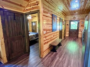 Un intérieur en bois avec un banc, une porte et une fenêtre.