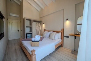 A bedroom with a wooden bed, a bedside table, a wall-mounted TV, and a built-in shelf with towels.