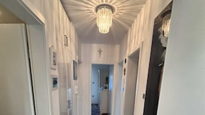 A hallway with a chandelier, a bench, and a door with a keyhole. - Apartment Sonja (Klimno - island Krk)