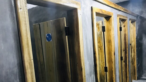 A row of wooden doors with a blue sign, likely indicating a specific area or function within a building. - Backpackers Villa (Arugam Bay)