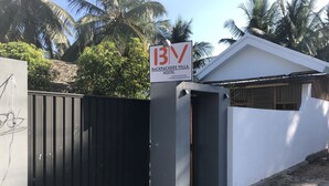 A gated entrance to Backpackers Villa Hostel with a sign indicating its name and location. - Backpackers Villa (Arugam Bay)