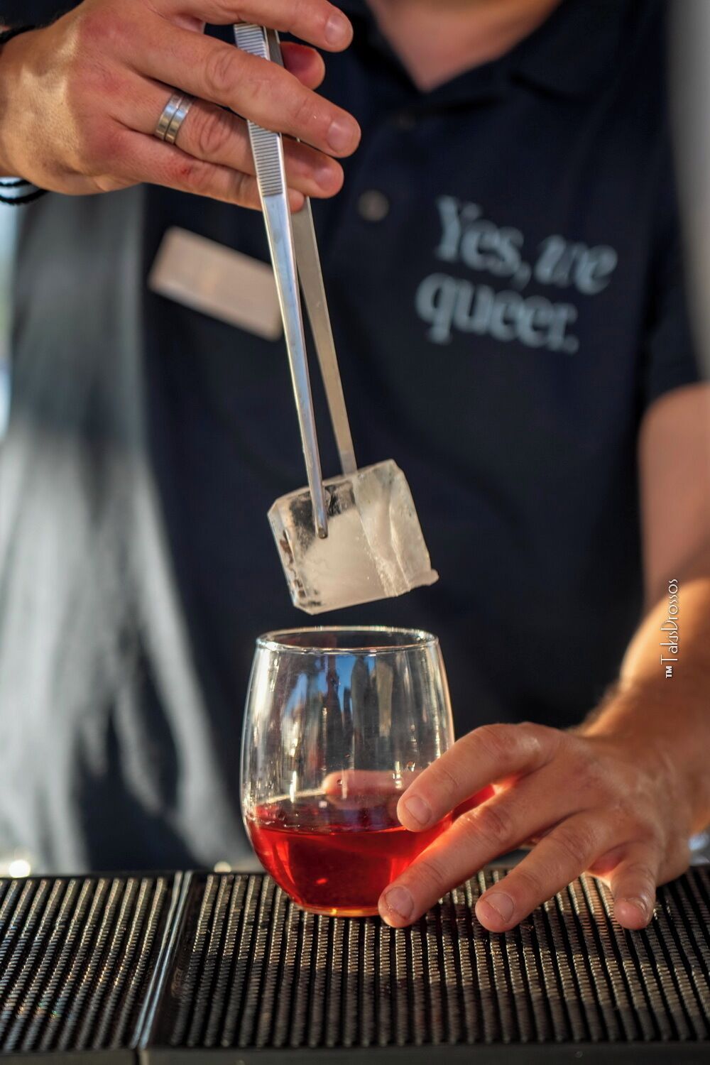 Une personne verse un liquide rouge dans un verre.