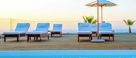 Seasonal outdoor pool, open 10:00 AM to 6:00 PM, pool umbrellas