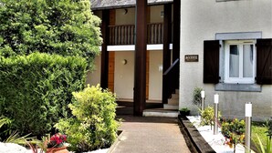 Un bâtiment doté d’une entrée couverte, d’une enseigne sur laquelle on peut lire « ACCUEIL », et avec une montagne en arrière-plan.