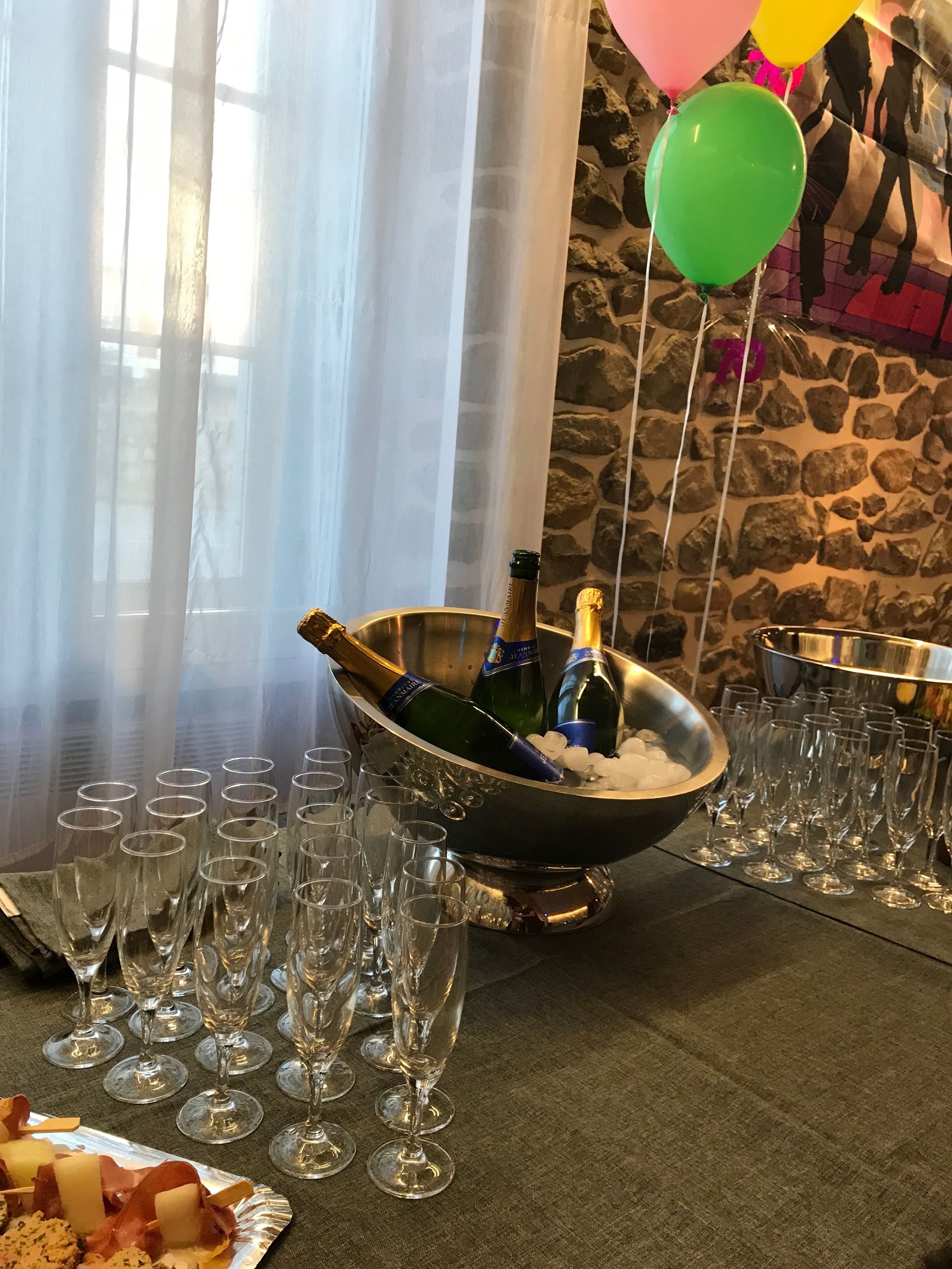 Una mesa servida con botellas de champán, hielo y copas de vino vacías.