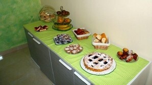 A buffet table with various food items and a cake. - B&B La Sciuscitta (Morciano di Leuca)