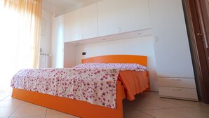 Ein Schlafzimmer mit einem Bett, einem Kleiderschrank und einer Tür.