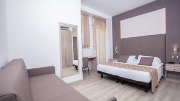 Una camera d'albergo moderna con un letto, una scrivania, una sedia e un divano.