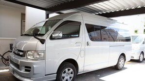 A white van parked under a covered area with a bicycle nearby. - Thanyaporn Hotel (Takayama)