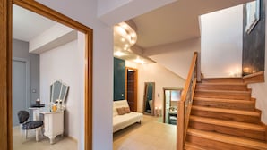 A staircase leading to a bedroom with a bed, a dresser, and a mirror. - Centro Houses (Santorini)