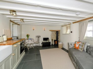 A cozy living room with a fireplace, a dining area, and a kitchen with modern appliances.