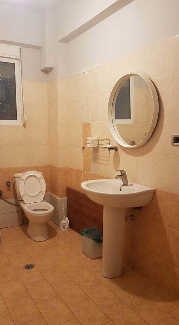 Un baño con inodoro, lavabo y espejo.