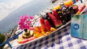 Una mesa con una bandeja de fruta y un menú de cócteles en primera línea de playa.