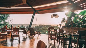 Un espacio para comer al aire libre con mobiliario de madera y vistas al paisaje.