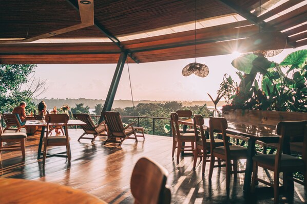 An outdoor dining area with wooden furniture and a view of the landscape.