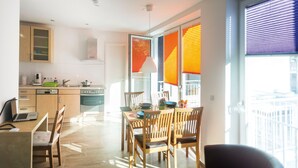 Una cocina moderna con armarios de madera, lavavajillas y un comedor con mesa y sillas.