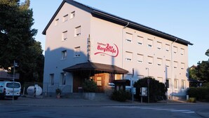 Et hotel med et skilt, der viser "Gasthaus Zur Bergstraße", grundlagt i 1957.