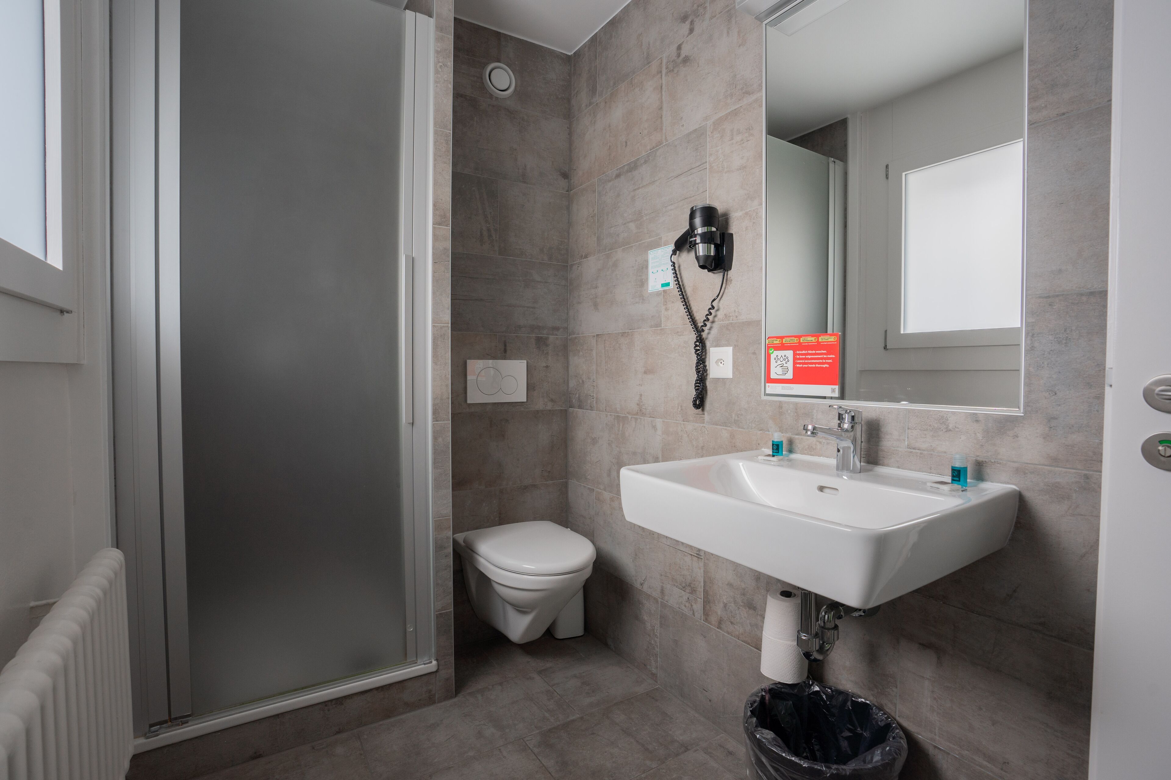 Un baño moderno con ducha, inodoro y lavamanos.