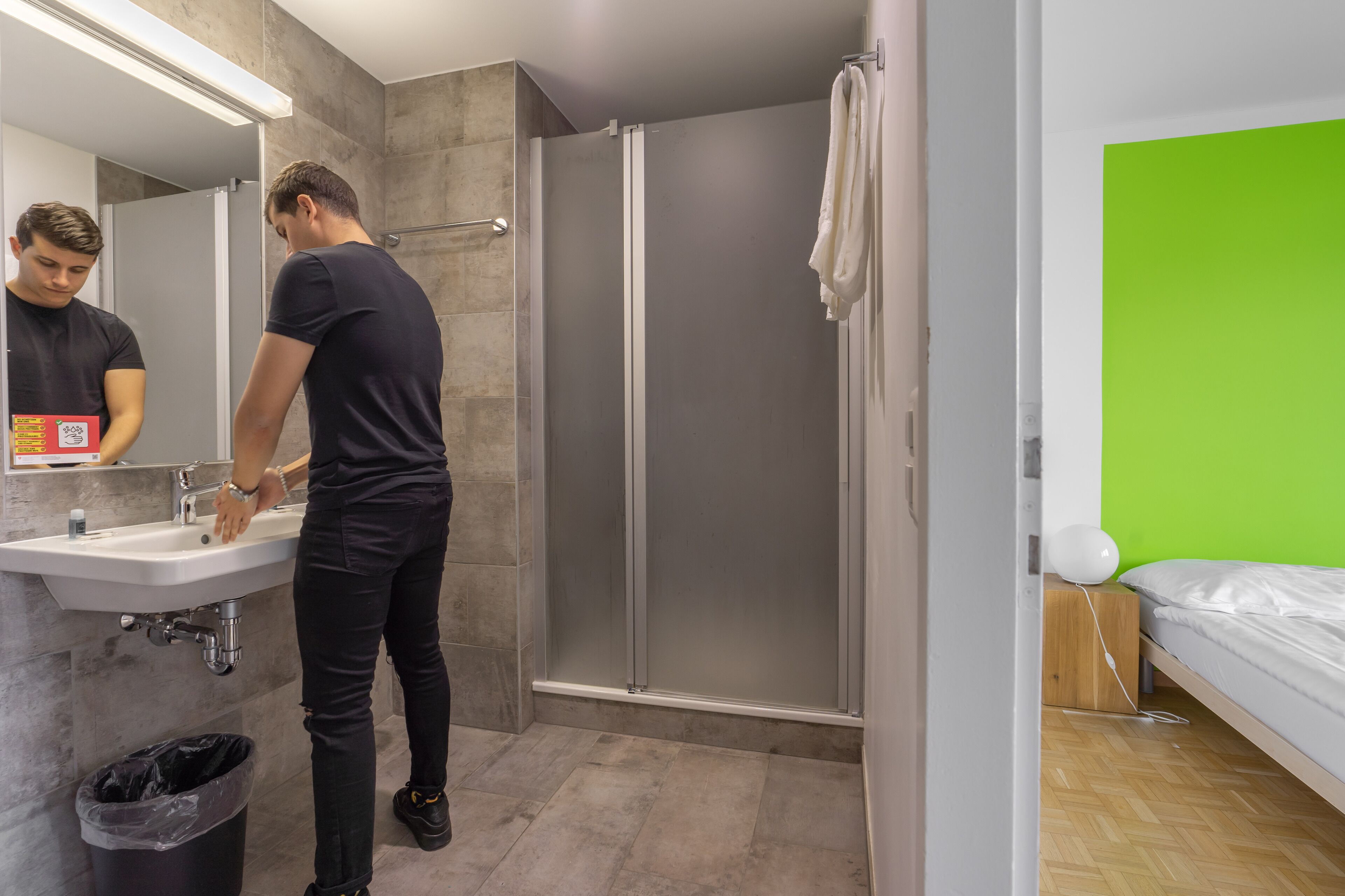 Un baño moderno con lavabo, espejo e inodoro con ducha.