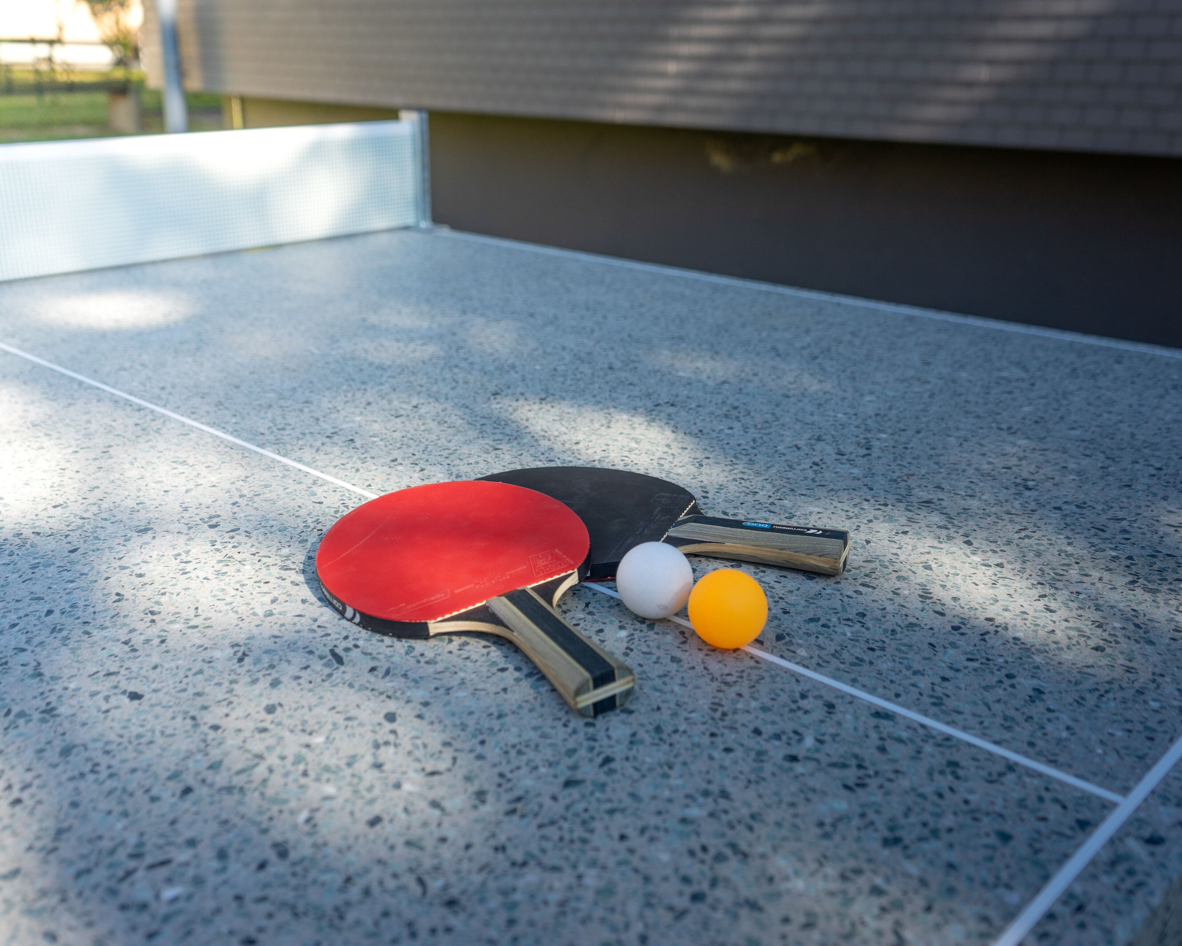 Une table de ping-pong avec deux raquettes et deux balles.