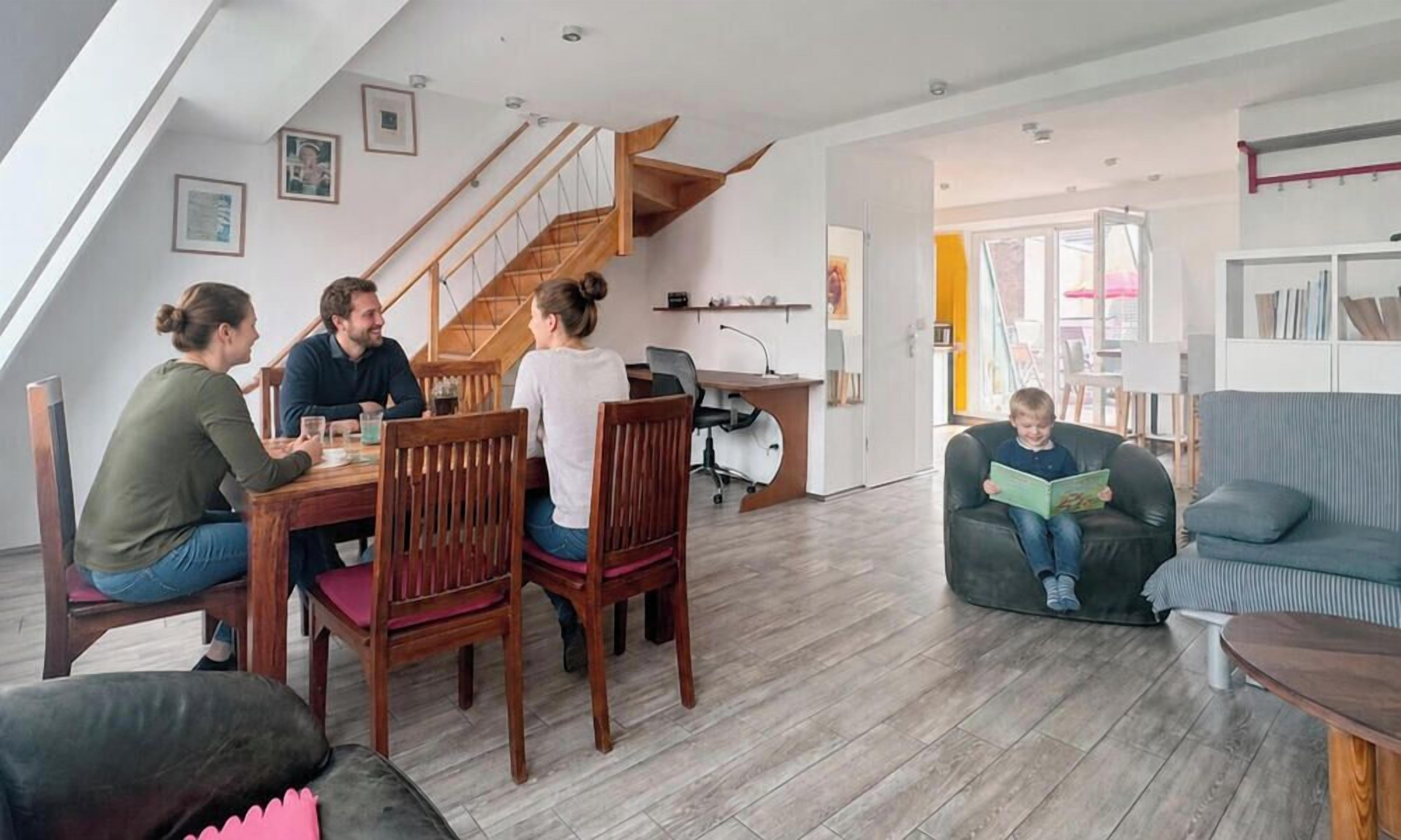 Un salon moderne comprenant un coin repas, un escalier et un coin lecture.