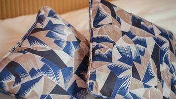 Two pillows with a geometric pattern on a bed.